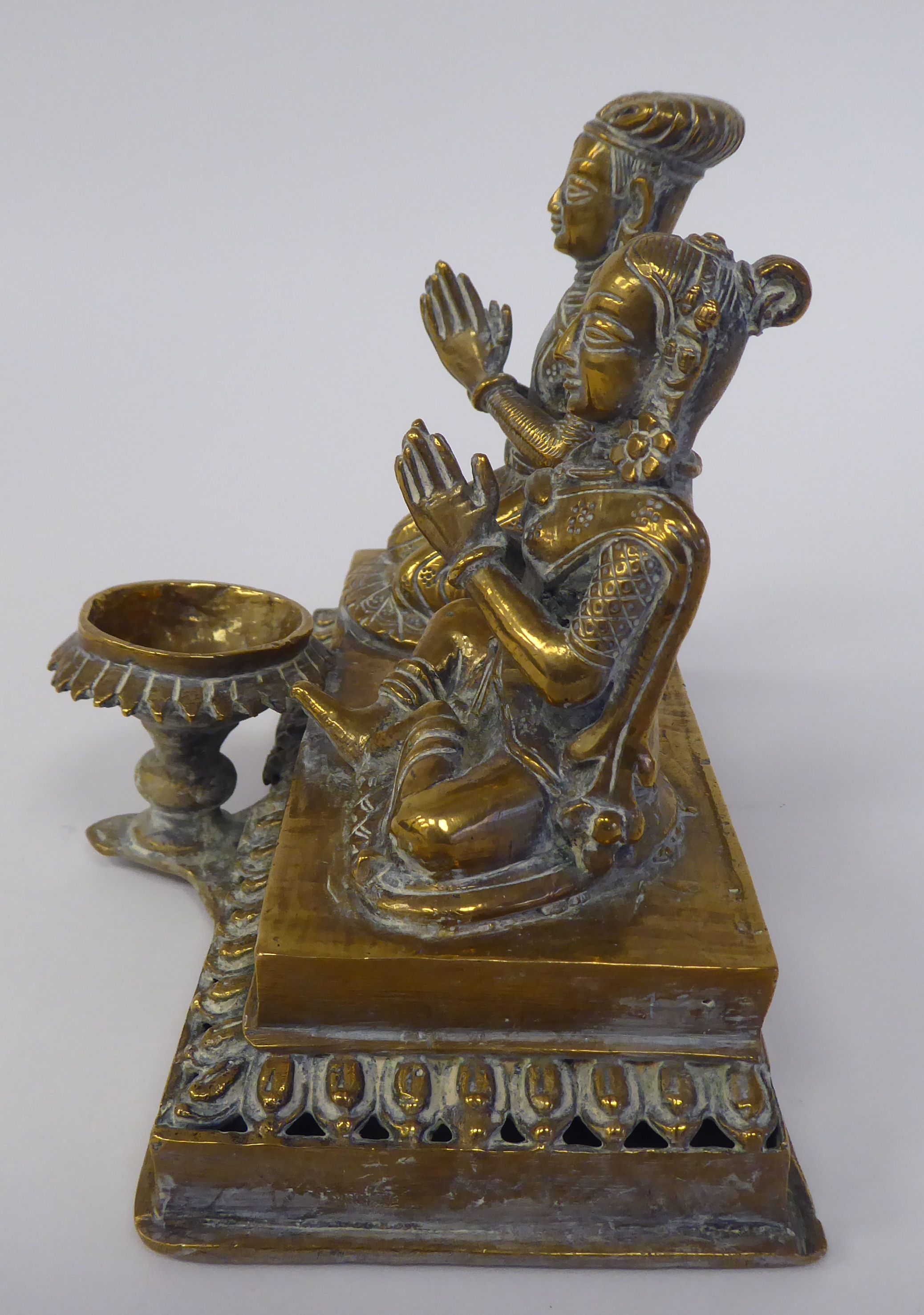 A pair of Asian brass religious deities, seated on a plinth between an outset pedestal vase  5"h - Image 2 of 4