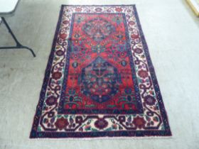 A Bactiar rug, decorated with floral and other stylised designs, on a multi-coloured ground  52" x