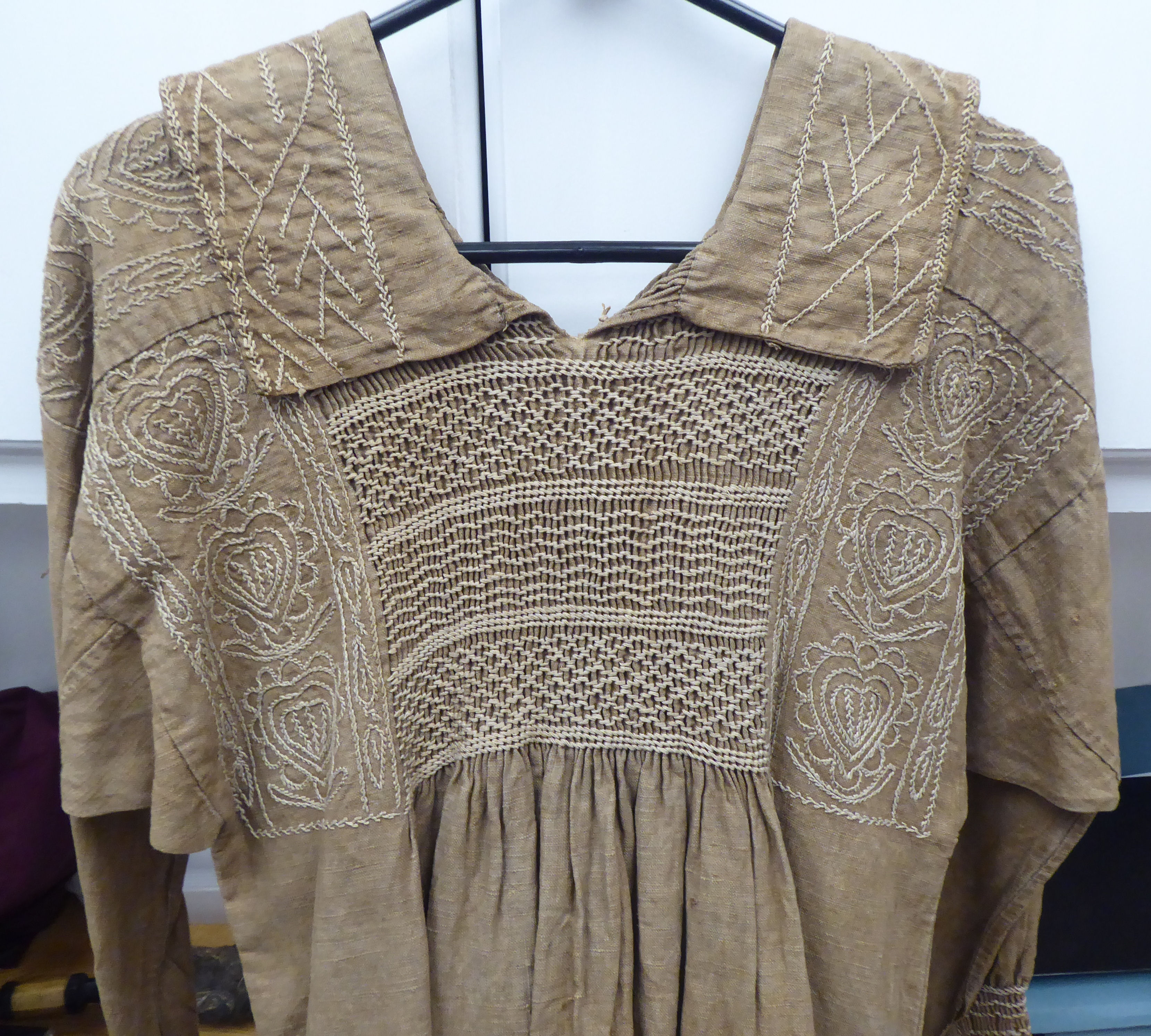 A Continental artisan's brown calico pleated dress with decorative, stone coloured embroidery and - Image 2 of 3