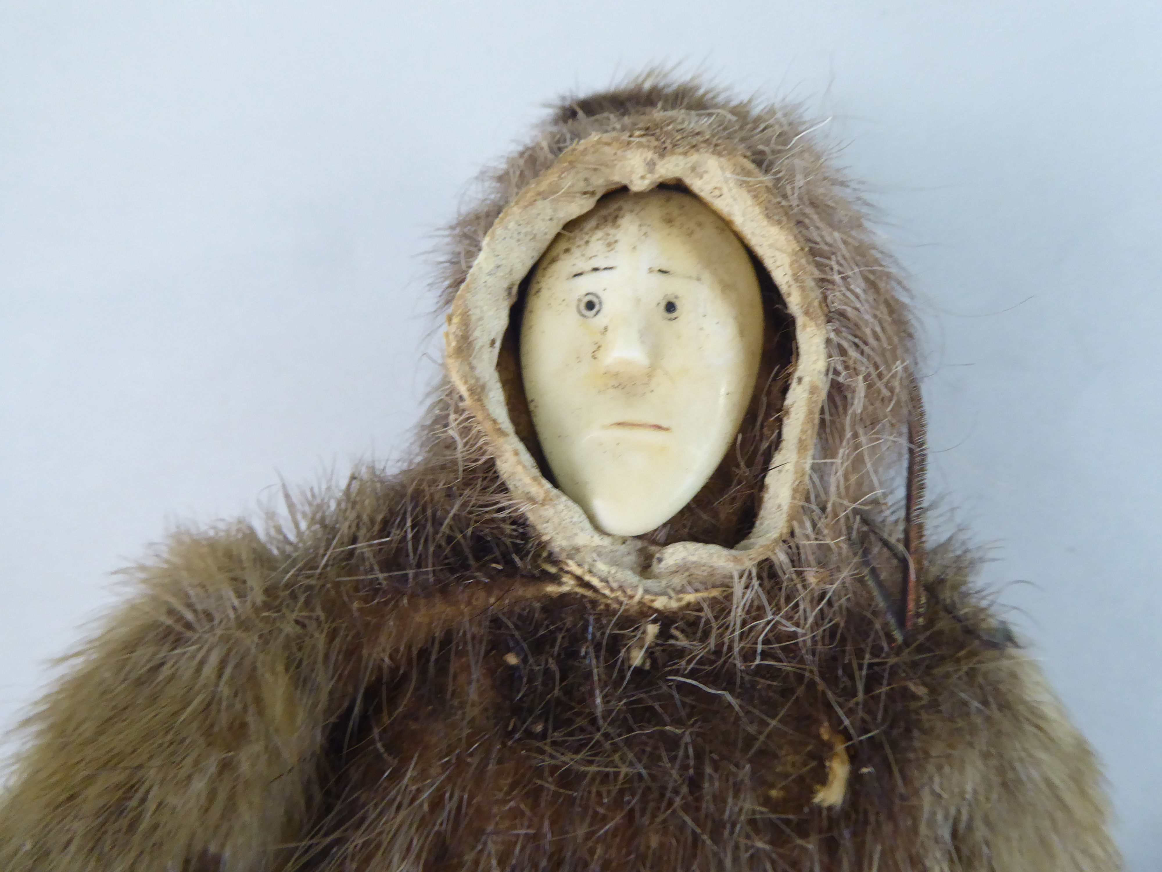 An early 20thC Inuit doll with a carved bone face and seal skin clothes  10.5"h - Image 2 of 4