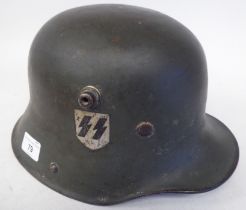 A German Great War military, steel helmet used by the SS in World War II with a hide liner and two