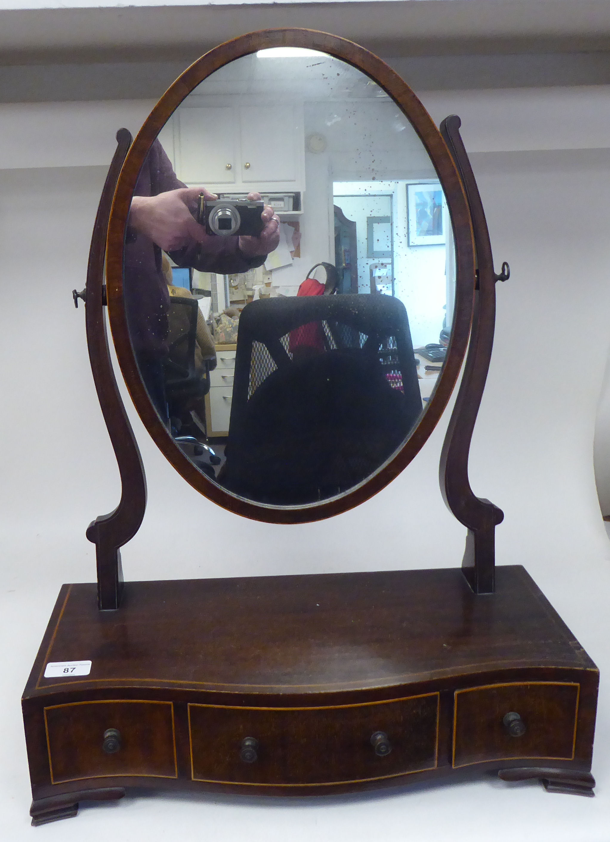 An Edwardian satinwood string inlaid mahogany toilet mirror, the oval plate pivoting on shaped