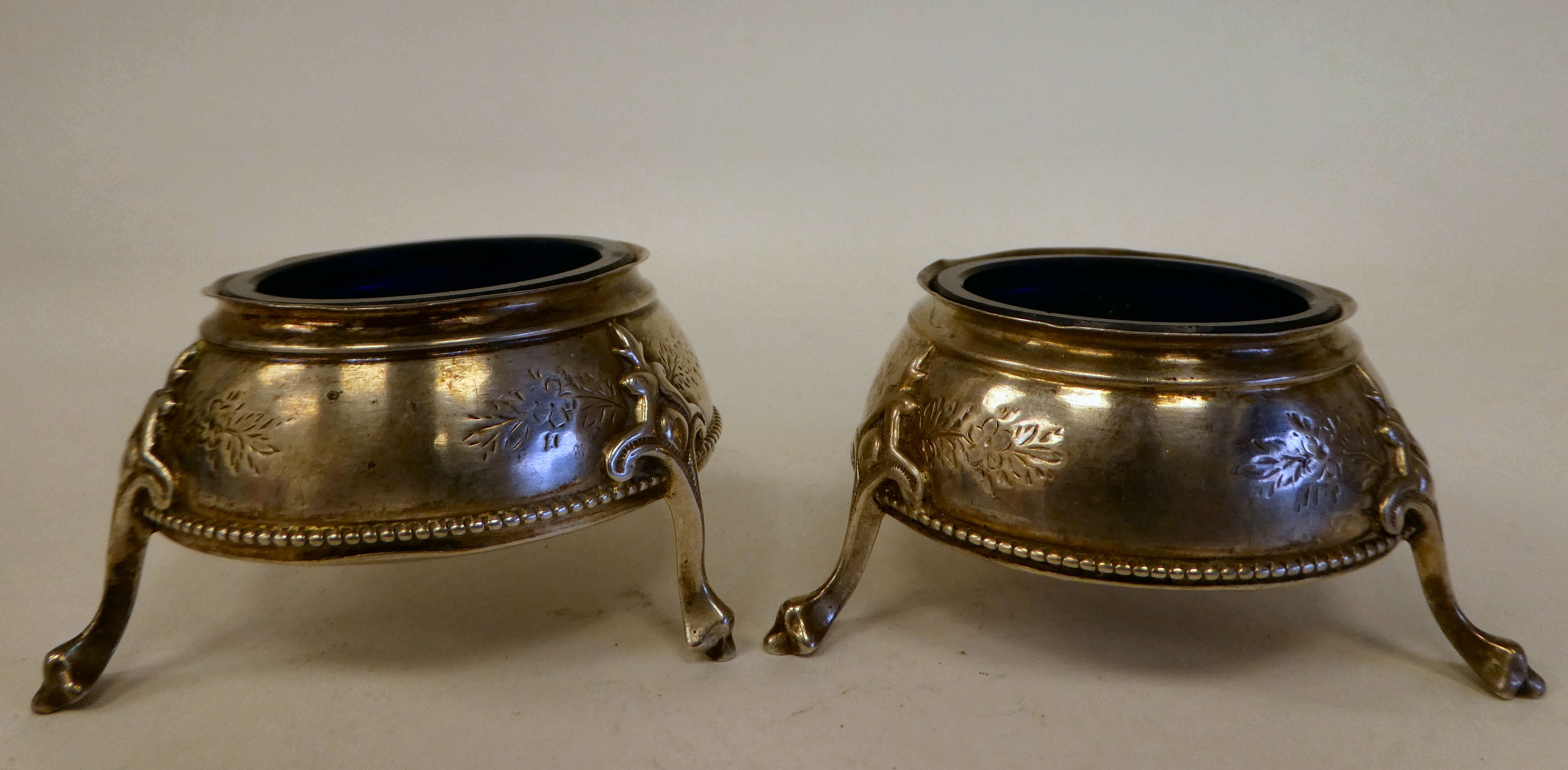 A pair of George III silver shallow, bulbous salt cellars with blue glass liners, on hoof feet - Image 5 of 8