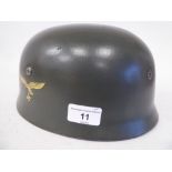 A German World War II Luftwaffe parachutist's steel helmet with a hide liner, harness strap and