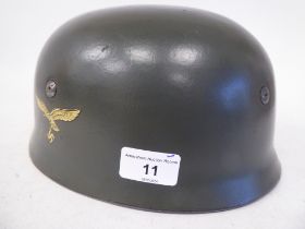 A German World War II Luftwaffe parachutist's steel helmet with a hide liner, harness strap and