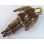An early 20thC Inuit doll with a carved bone face and seal skin clothes  10.5"h