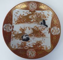 A late 19thC Japanese Kutani style porcelain charger, decorated in with vignette studies of birds,