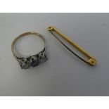 A 9ct gold claw set, three stone ring; and a 9ct gold bar brooch