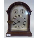 A late 19th/early 20thC mahogany round arched cased mantel clock with a full-height window, on a