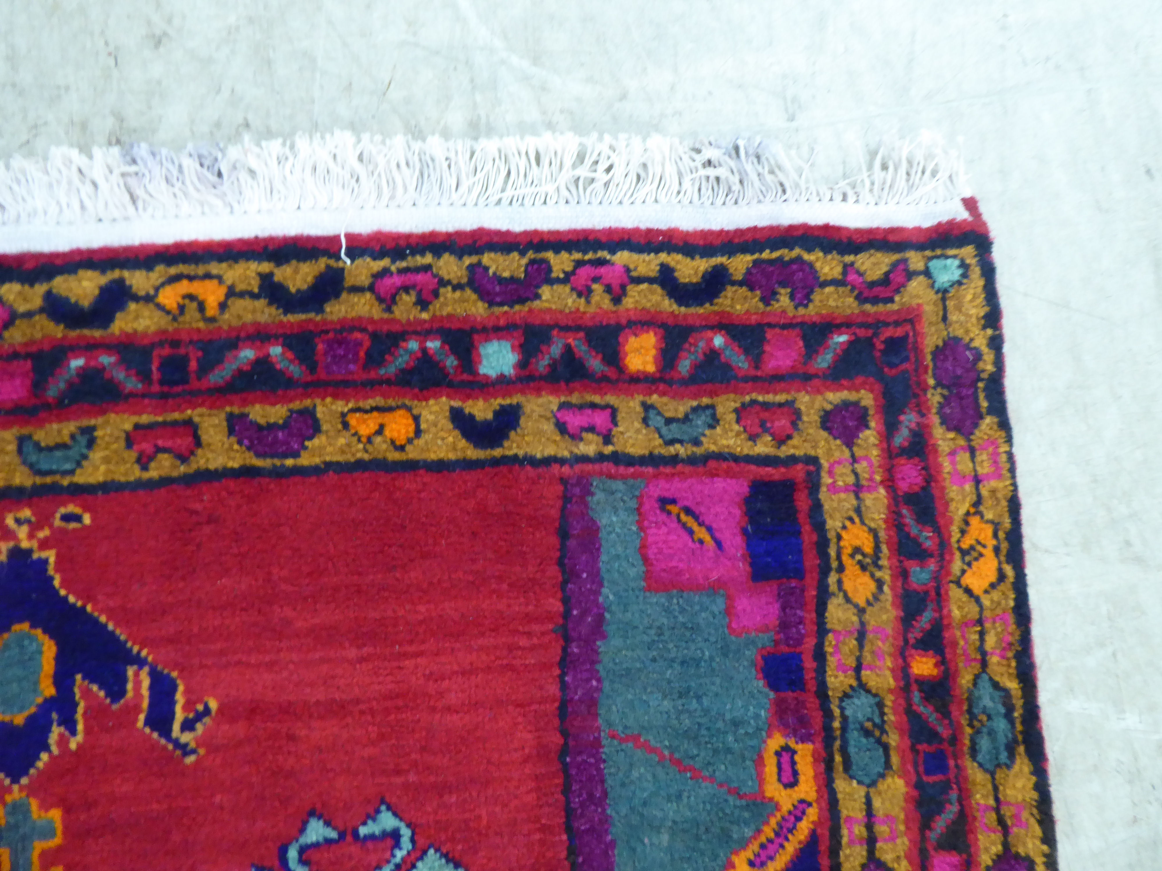 A Turkish rug with stylised designs, on a mainly red ground  52" x 88" - Image 3 of 4