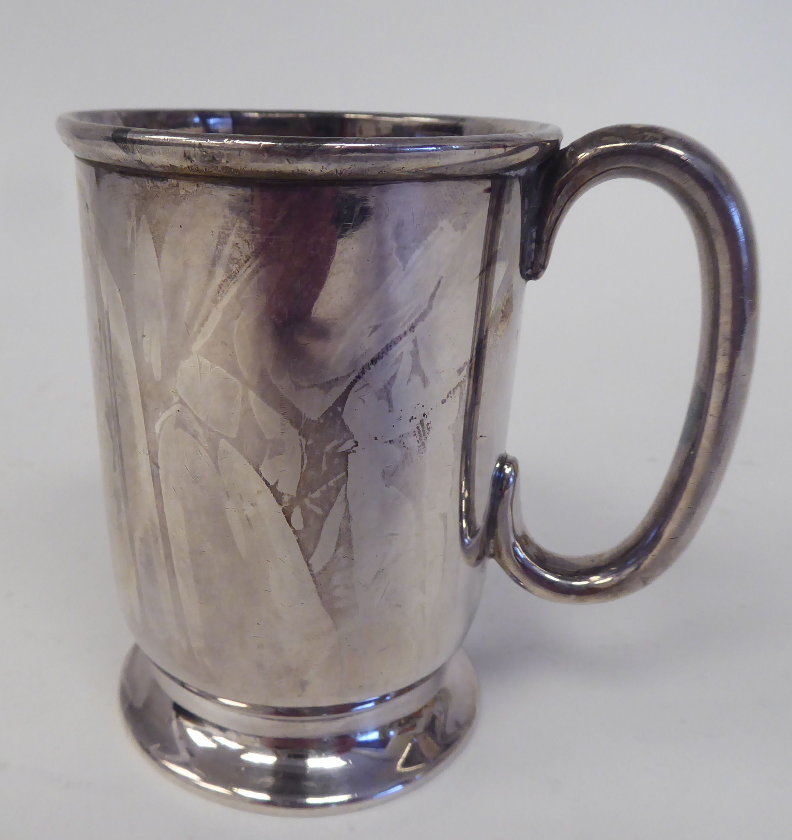 A silver Christening mug with a rolled rim and hollow C-scrolled handle, on a splayed footrim  Henry