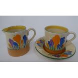 A Clarice Cliff Bizarre, Newport Pottery, Crocus pattern cream jug; and a demi-tasse coffee can