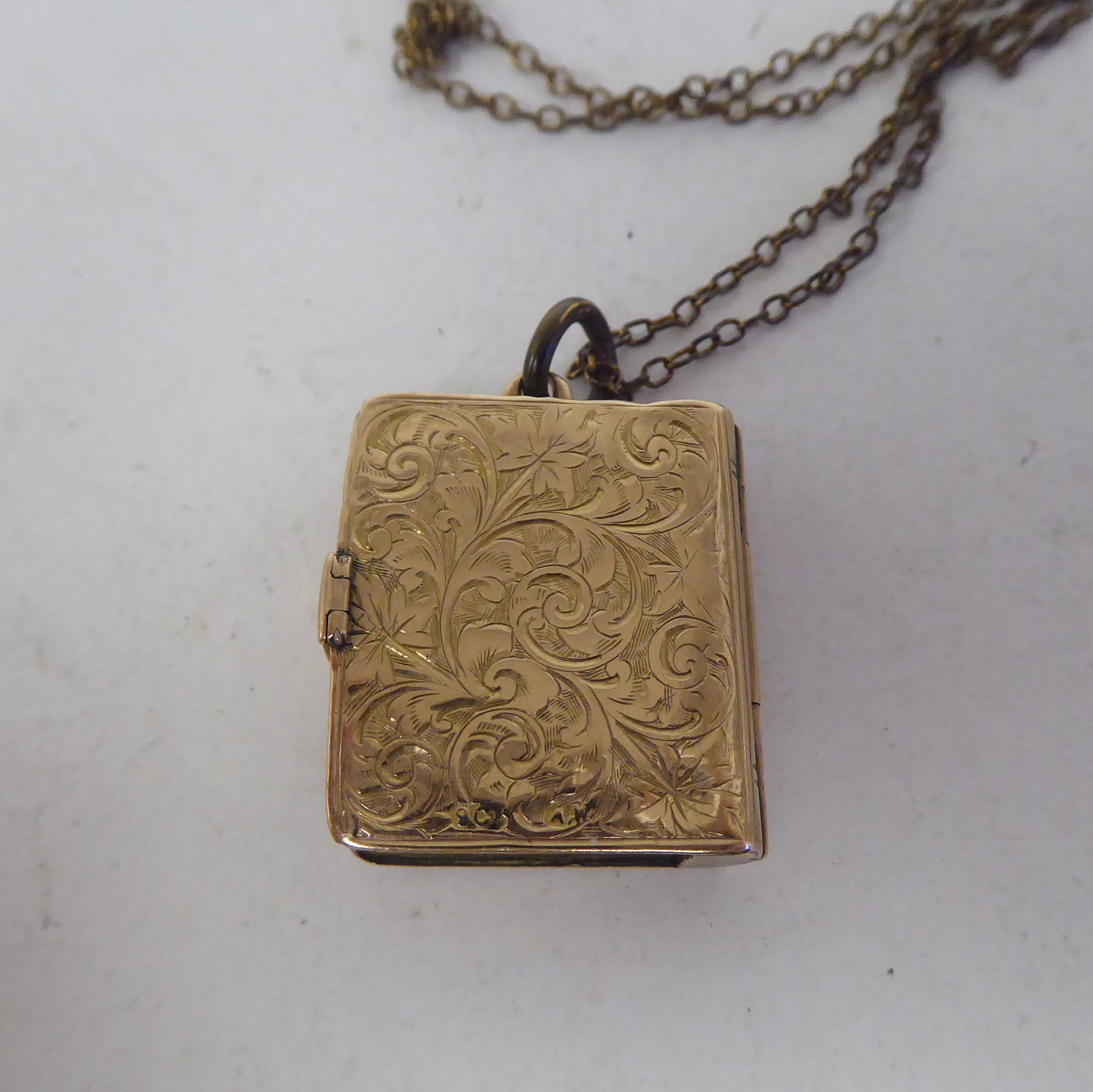 A late Victorian foliate scrolled yellow metal locket, fashioned as a book, on a clasp, revealing - Image 4 of 7