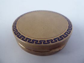 A 9ct gold engine turned and blue enamel, circular powder compact with a hinged lid and inset vanity