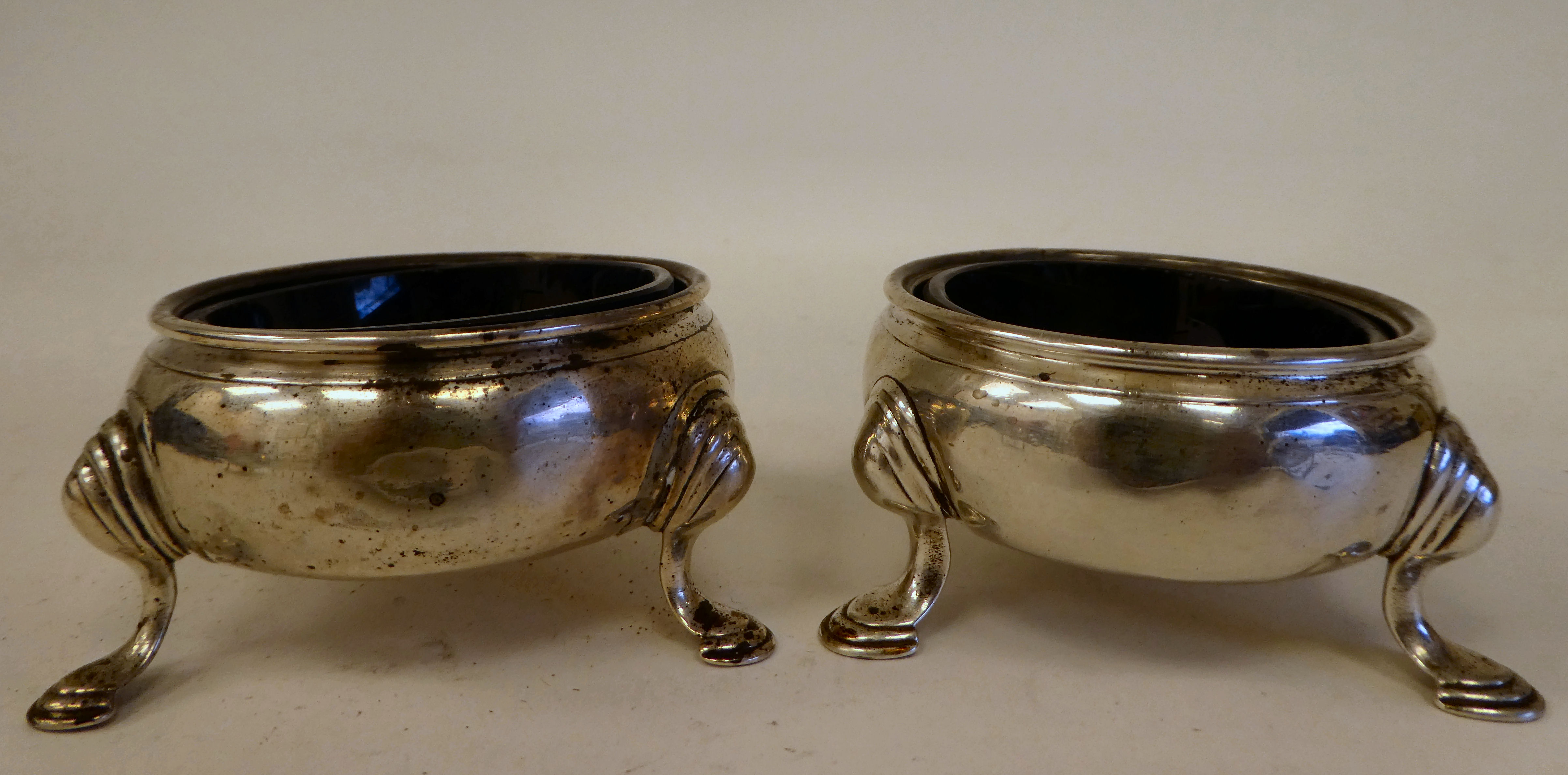 A pair of George III silver shallow, bulbous salt cellars with blue glass liners, on hoof feet - Image 2 of 8