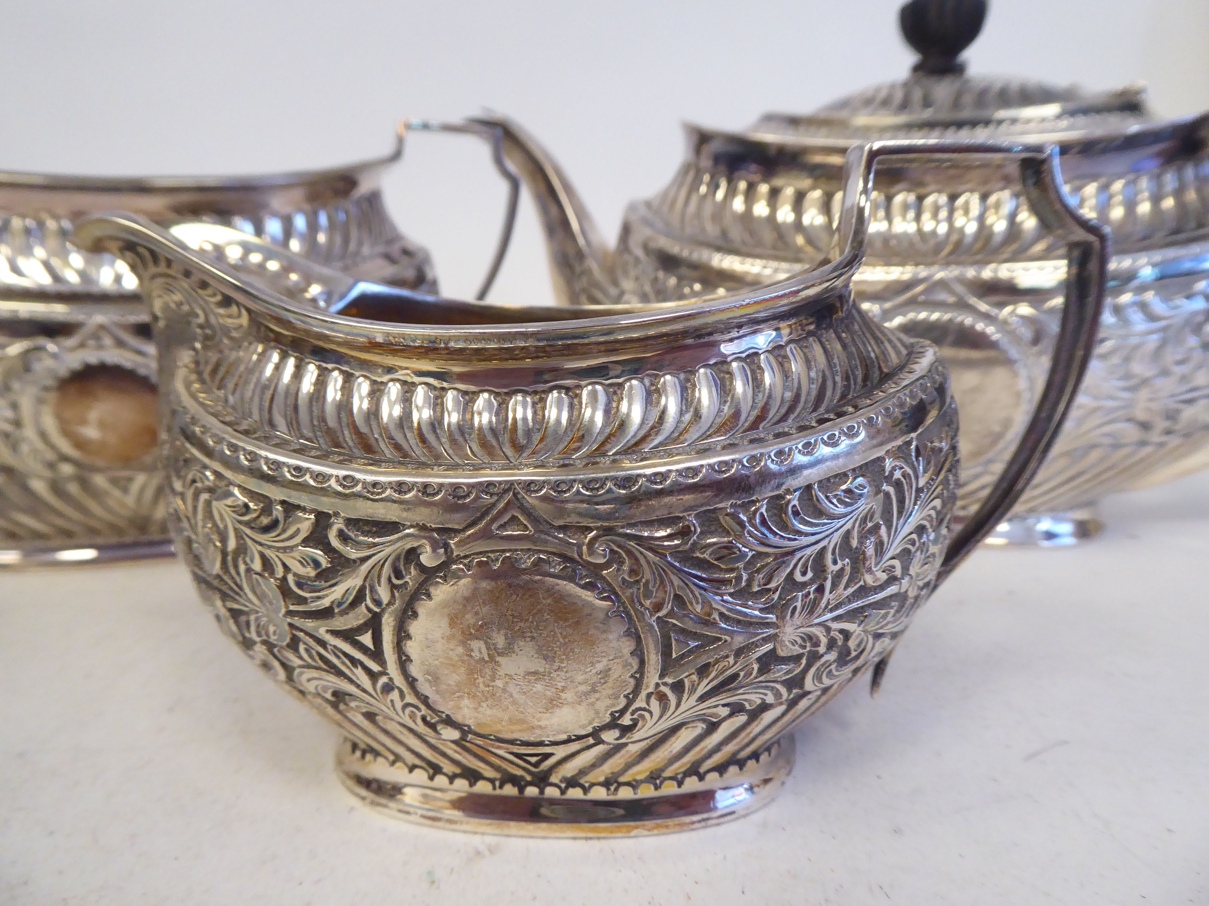 A late Victorian silver three piece tea set of oval form with engraved, chased and demi-reeded - Image 2 of 10