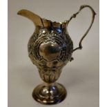 A late Victorian silver pedestal cream jug of pear form with a double C-scrolled handle, scaled,