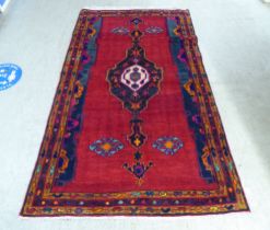 A Turkish rug with stylised designs, on a mainly red ground  52" x 88"