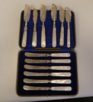 A set of six silver dessert knives, on mother-of-pearl handles  cased; and a matched set of