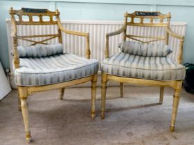 A pair of early 20thC Regency inspired, cream painted and gilded elbow chairs with low, curved