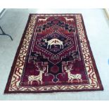 A Lori rug, decorated with stags and other animals, on a mainly red ground  66" x 96"