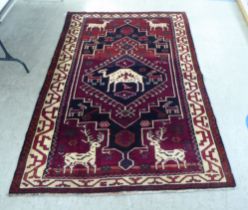 A Lori rug, decorated with stags and other animals, on a mainly red ground  66" x 96"