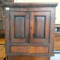 An early 19thC Georgian mahogany hanging corner cupboard with two fielded panelled doors, over a