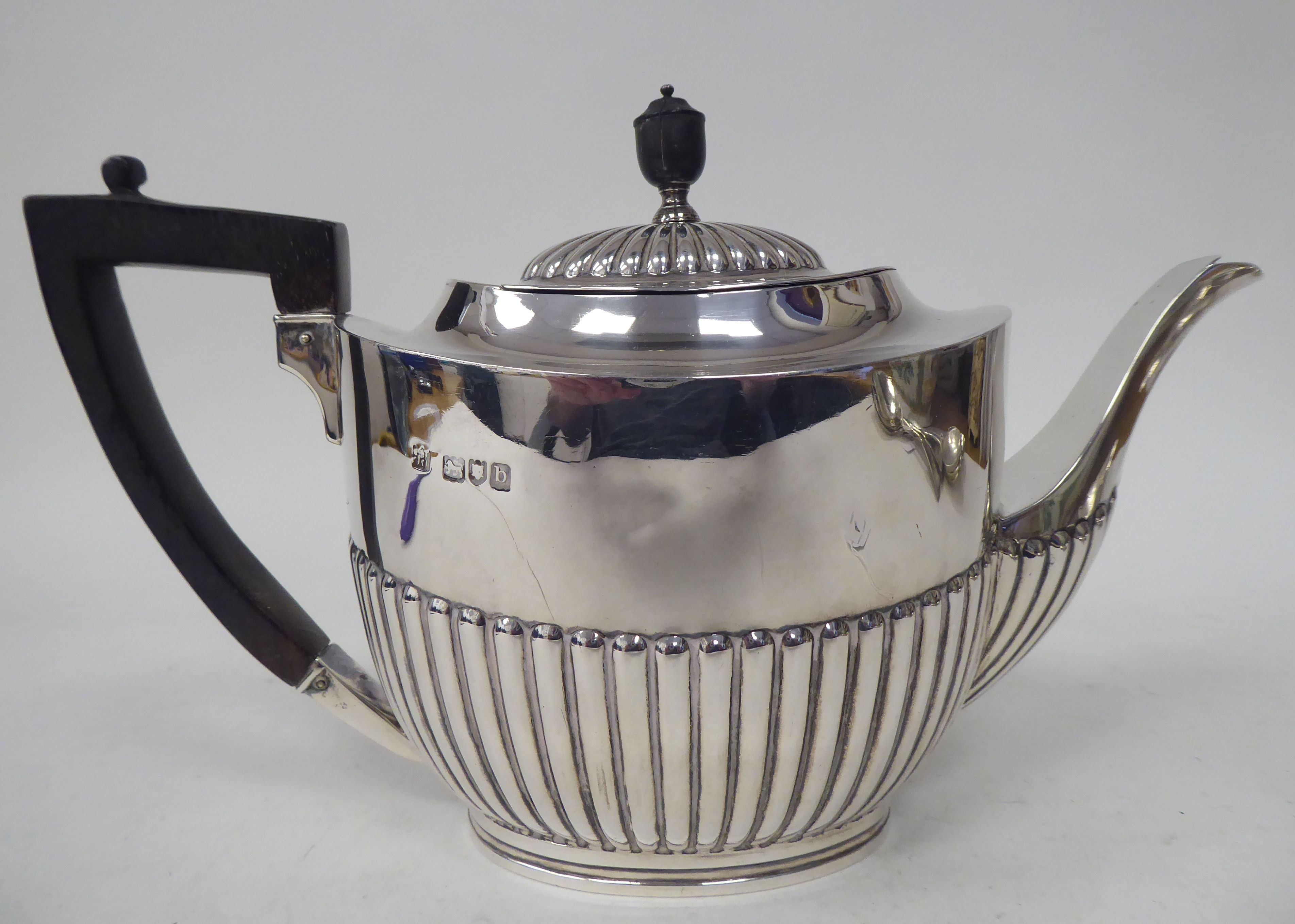 A late Victorian silver teapot of oval, demi-reeded form with a swept spout, hinged lid, ebonised - Bild 3 aus 4
