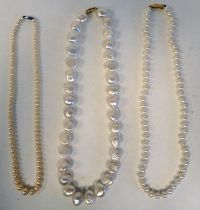 Three single strand pearl necklaces, each on a yellow metal clasp