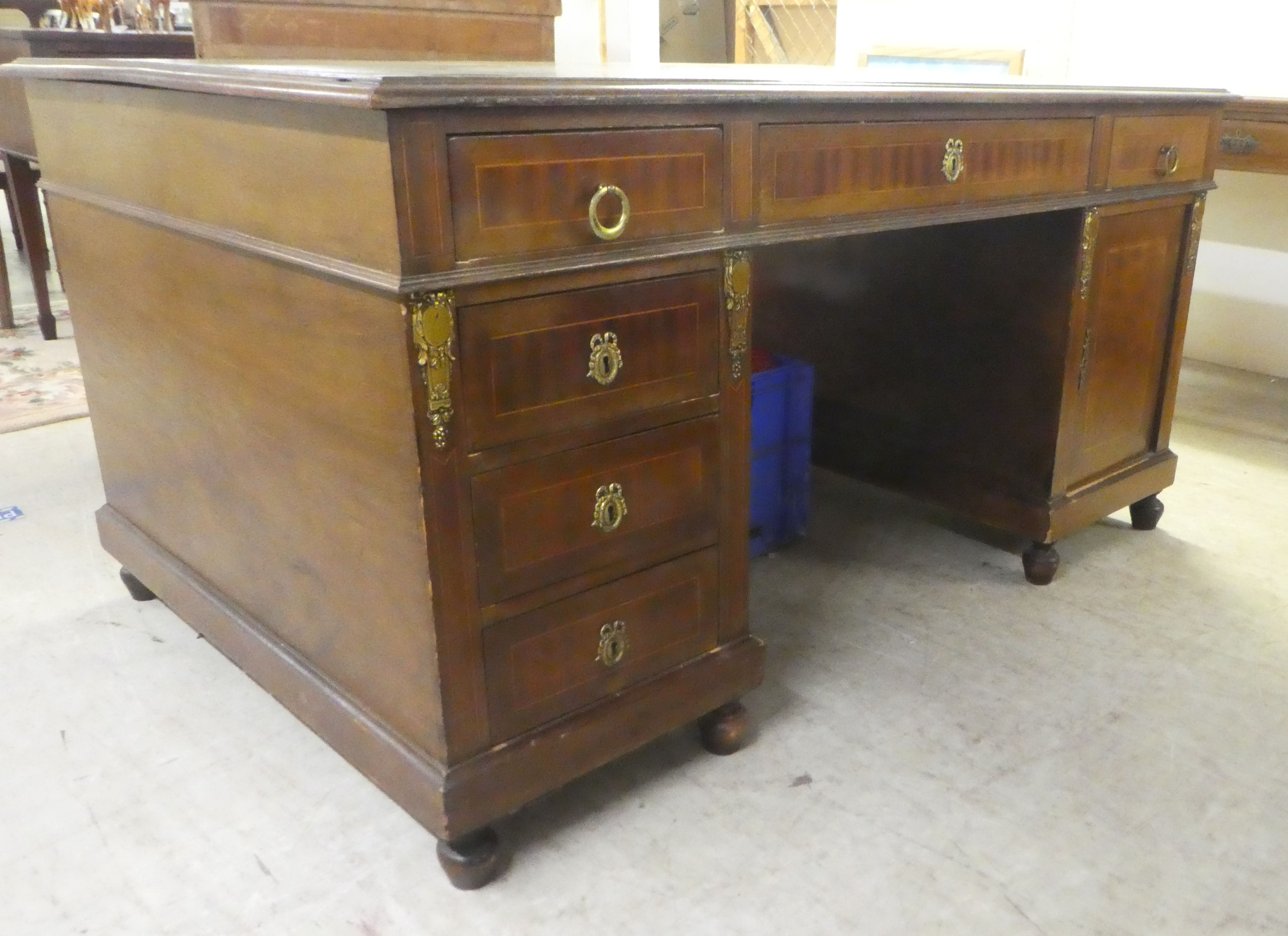 An early 20thC string inlaid mahogany, twin pedestal partner's desk with an arrangement of drawers