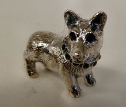 A silver coloured metal miniature model standing dog with an emerald set collar  stamped Sterling