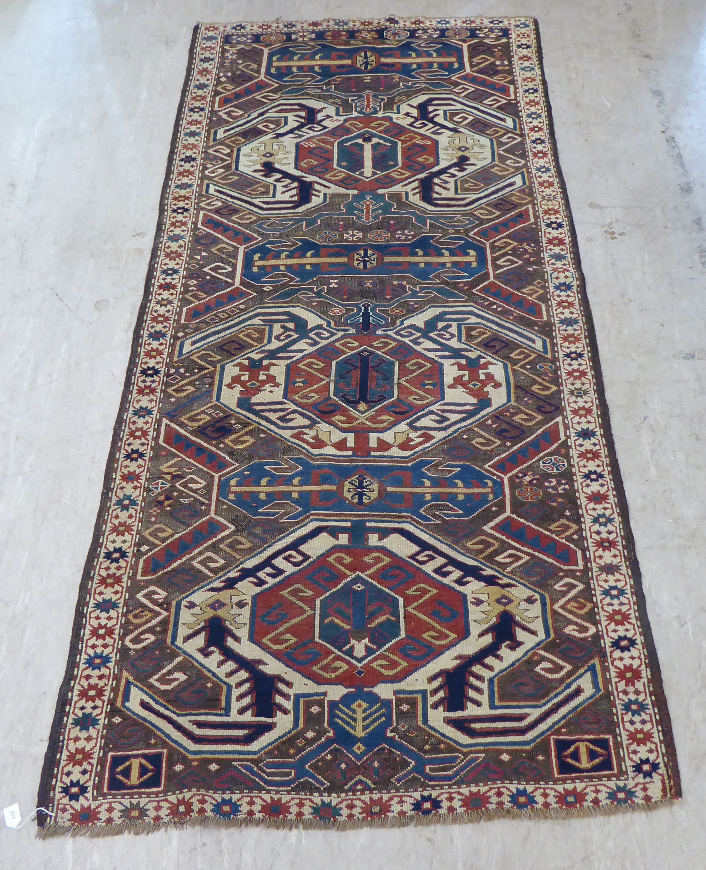 A Turkish Kilim style runner, decorated with repeating stylised designs, on a multi-coloured ground