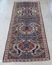 A Turkish Kilim style runner, decorated with repeating stylised designs, on a multi-coloured ground