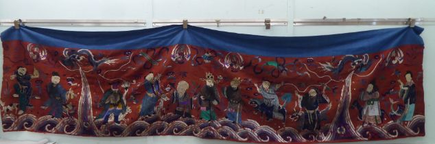 An early 20thC Chinese embroidered tapestry, depicting figures  120" x 34"