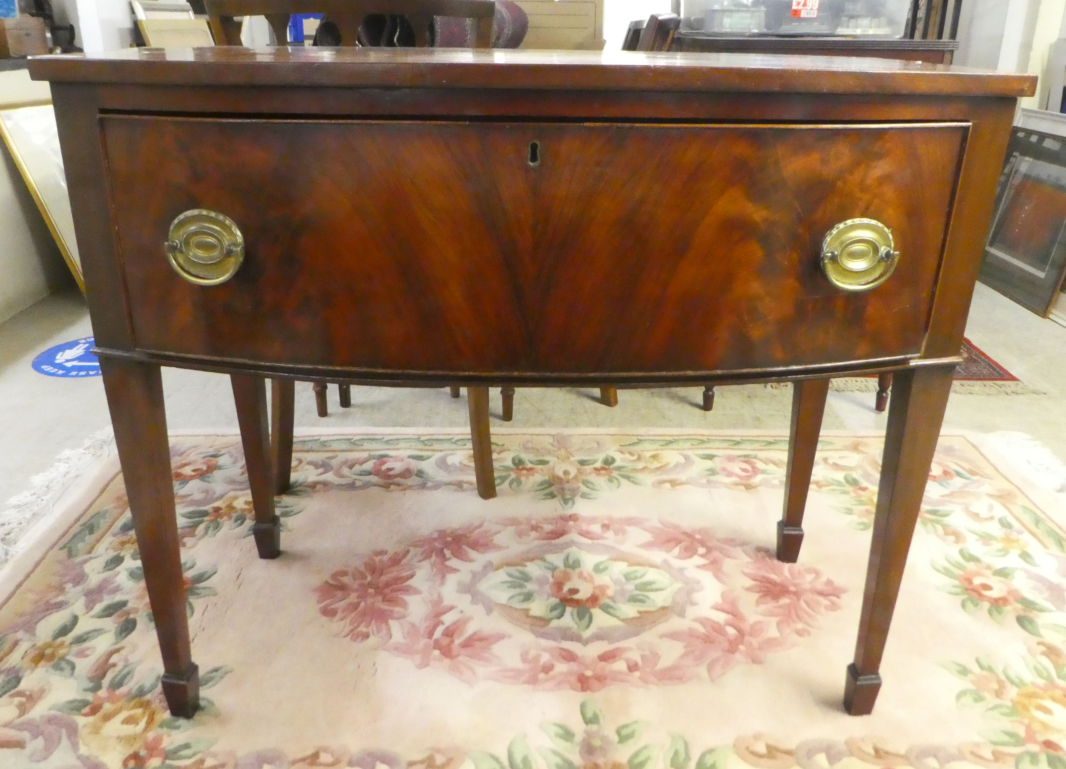 A late 19thC ebony inlaid mahogany bow front single drawer serving table, raised on square,