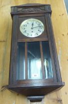 A 1930s oak cased wall clock, faced by an Arabic dial  32"h  14"w