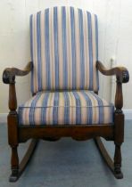 A mid 20thC stained beech framed, open arm rocking chair with a later fabric upholstered,
