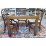 A modern mahogany dining table with an inset glass top, raised on square legs  30"h  39"sq; and a