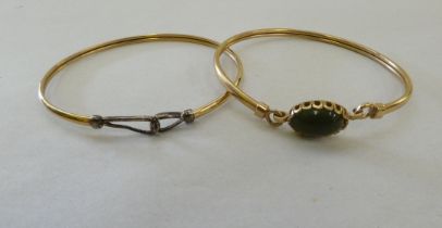 Two 9ct gold bangles, one set with an oval stone