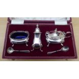 A three piece silver condiments set  comprising a pepper pot, salt and mustard pot  Sheffield