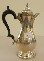 A Queen Anne design silver hot water pot with an ebonised handle  Birmingham 1929  9"h