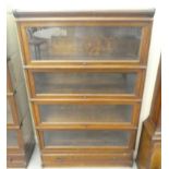A 1920s/30s oak Globe Wernicke four section bookcase with lift and slide doors and a base drawer, on
