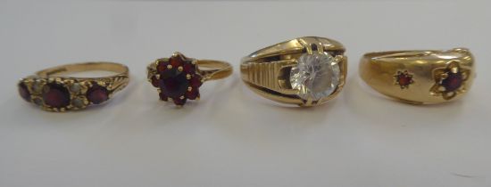 Four variously set 9ct and gold coloured metal rings