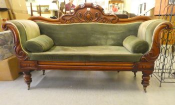 A William IV mahogany framed scroll end settee, upholstered in green fabric, raised on turned legs