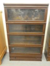 A 1920s/30s oak Globe Wernicke four section bookcase with lift and slide doors and a base drawer, on