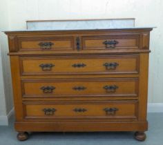 An early/mid 20thC oak commode, the fixed grey/white marble top, over two short/three long