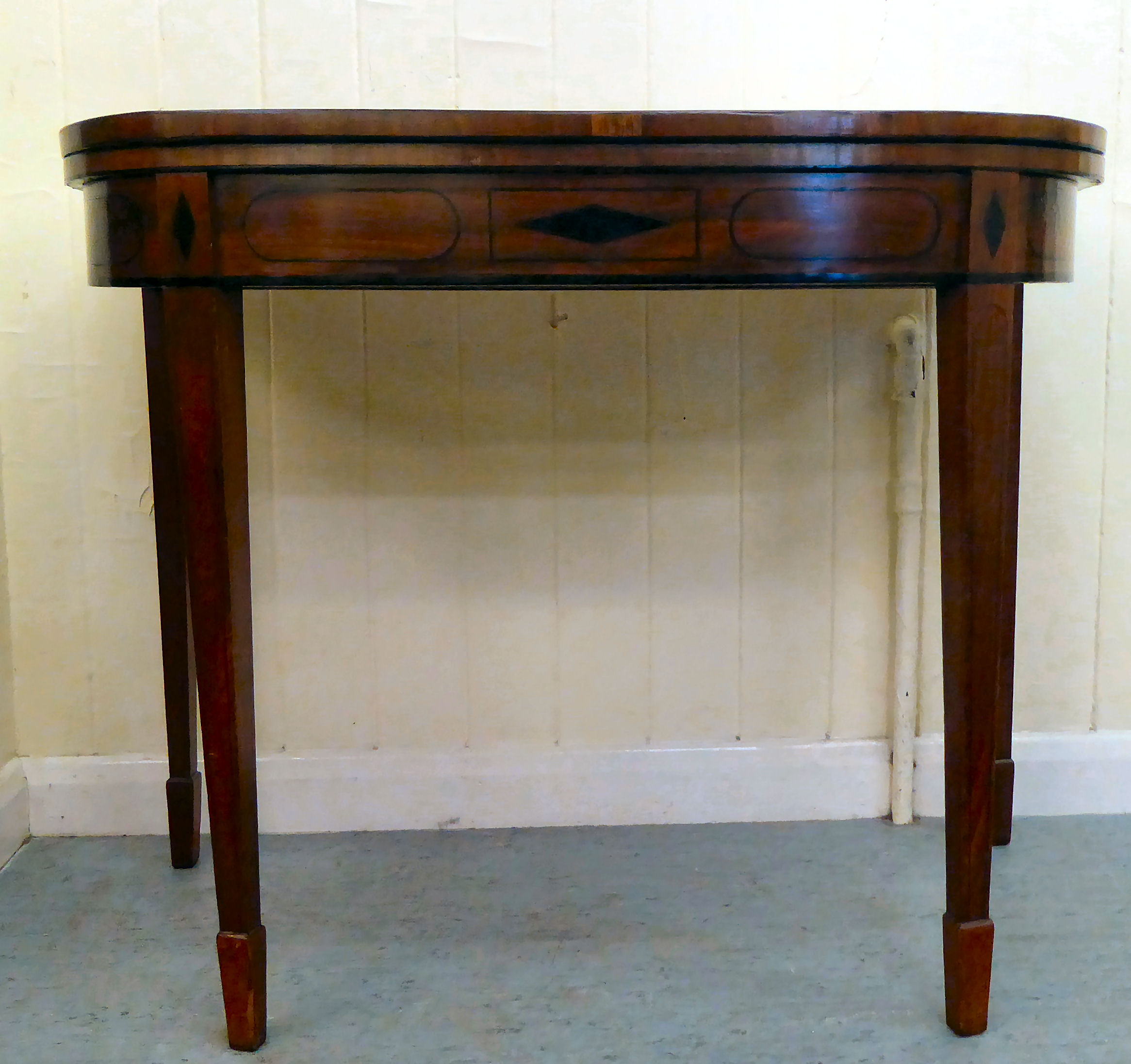 A 19thC string inlaid crossbanded mahogany D-end card table, the hinged top raised on square,