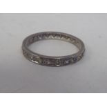 A white metal eternity ring, set with diamonds