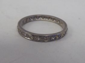 A white metal eternity ring, set with diamonds