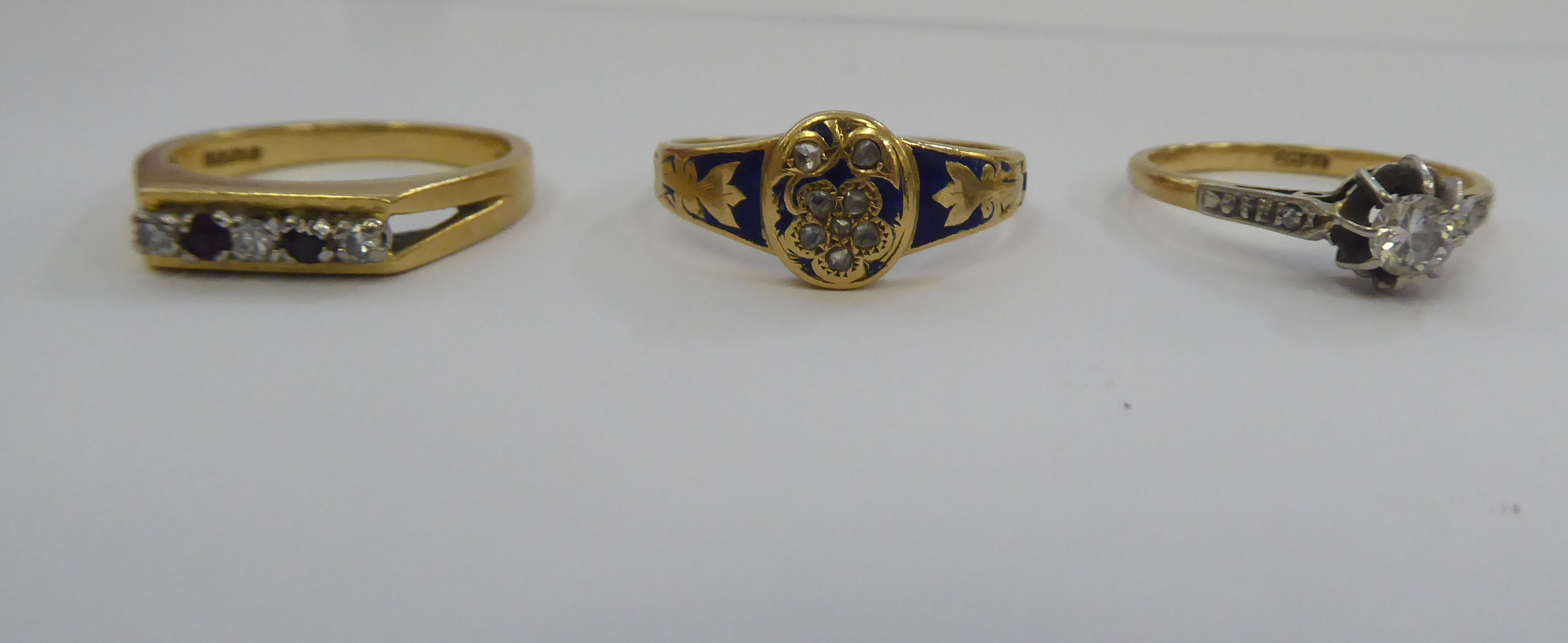 A late Victorian 18ct gold and blue enamel mourning ring; an 18ct gold claw set diamond ring; and